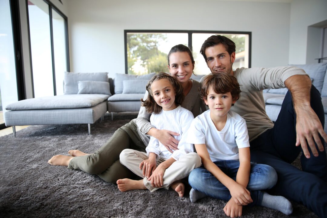 Family of four sitting on the living room floor in their remodeled Ridgefield WA home